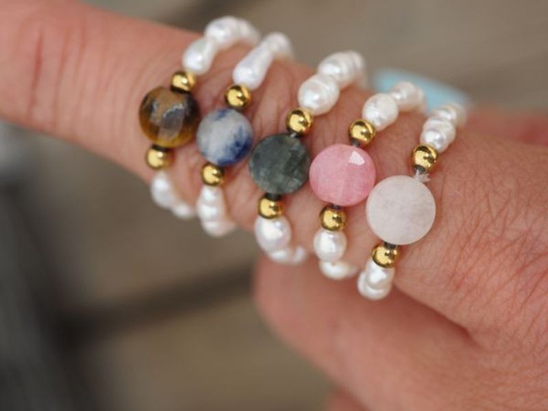 ring med perler og brun sten